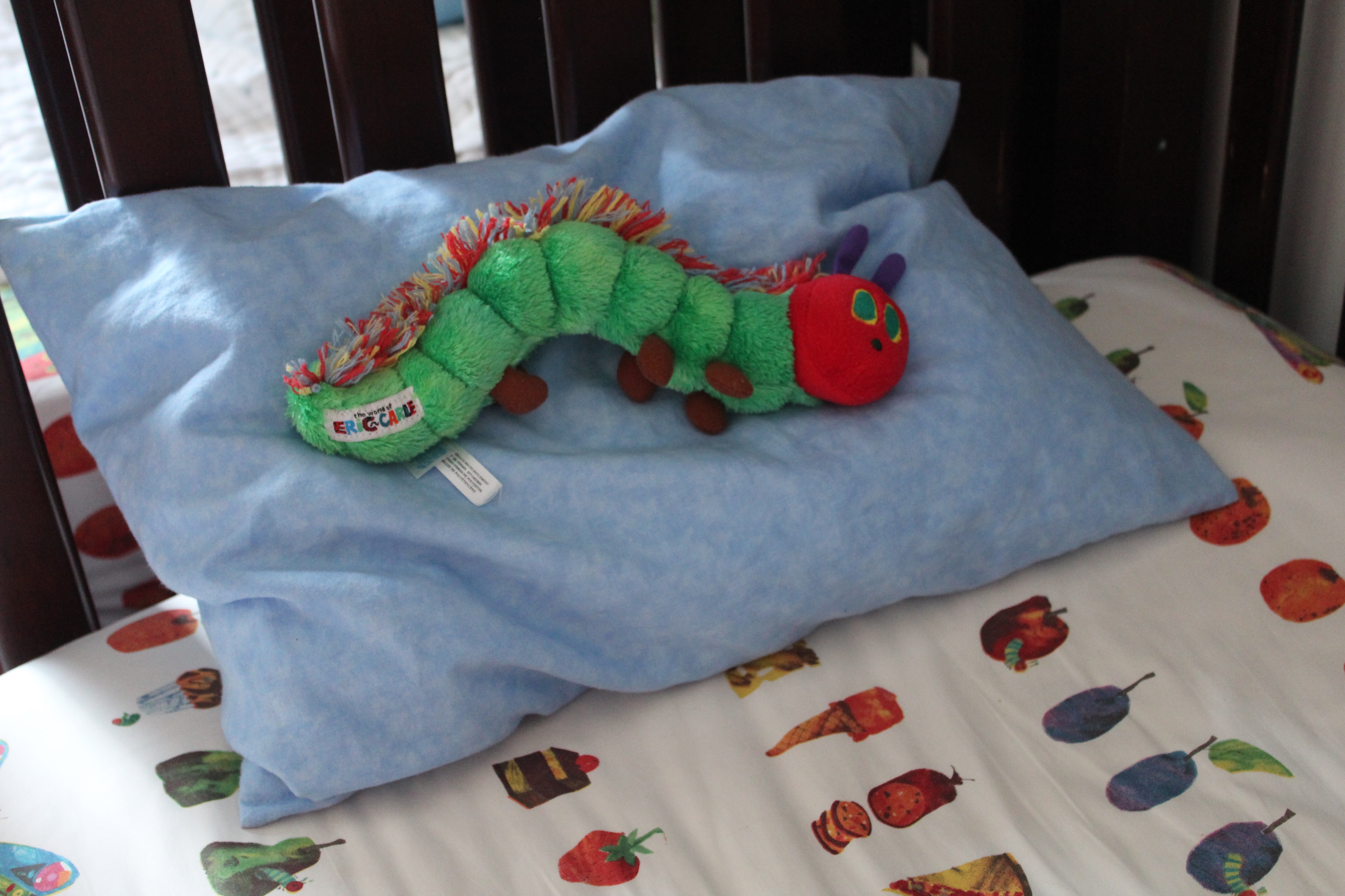 Very Hungry Caterpillar doll on Very Hungry Caterpillar bedspread.